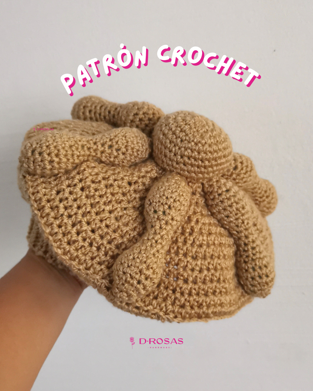 Boina en forma de pan de muerto tejida en crochet o gancho, color pan detalles en relieve que asemejan la forma del pan representativo de día de muertos. Letras que dicen Patrón crochet en la parte superior.